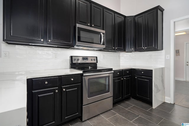 kitchen with stainless steel appliances and decorative backsplash