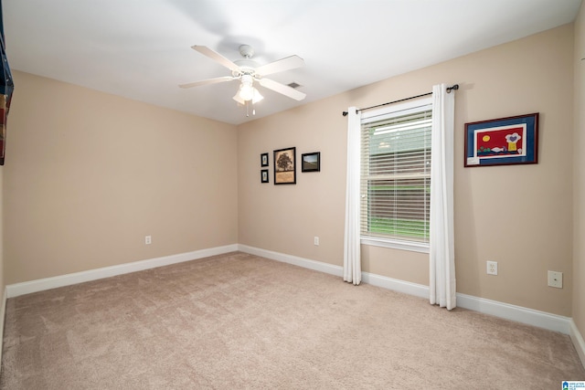 carpeted spare room featuring ceiling fan