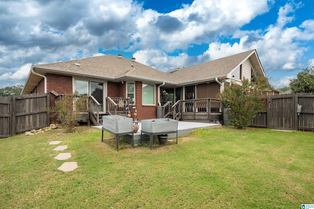 rear view of house with a deck and a yard