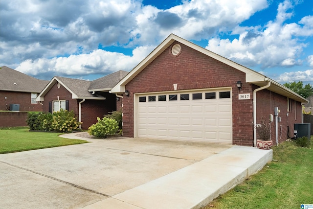 view of front of property featuring a garage, central AC, and a front yard