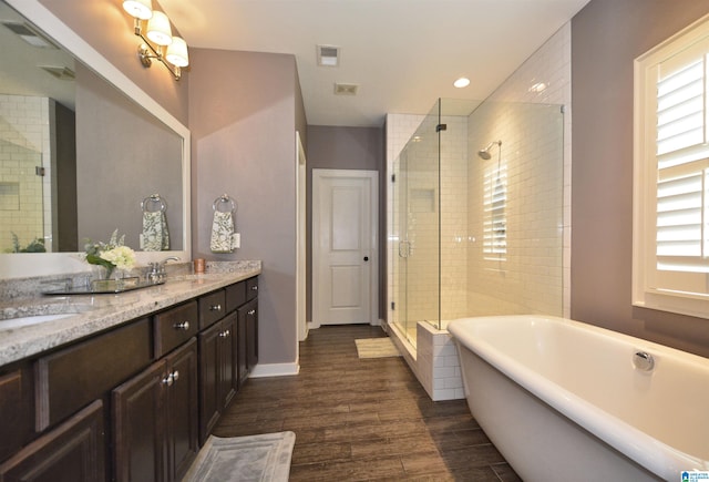 bathroom with plenty of natural light, independent shower and bath, wood-type flooring, and vanity