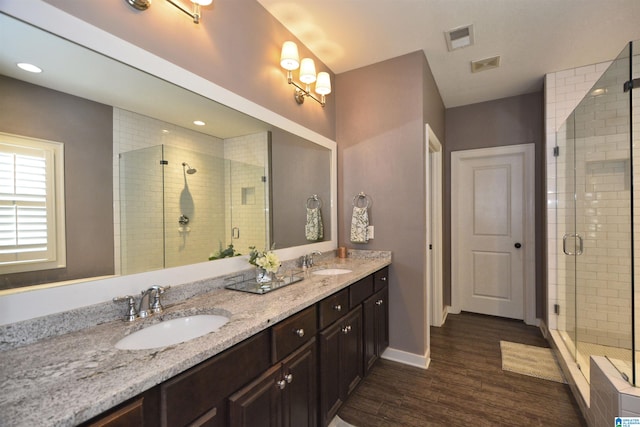 bathroom featuring vanity, hardwood / wood-style floors, and a shower with door