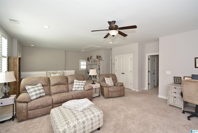 living room with plenty of natural light, ceiling fan, and light colored carpet