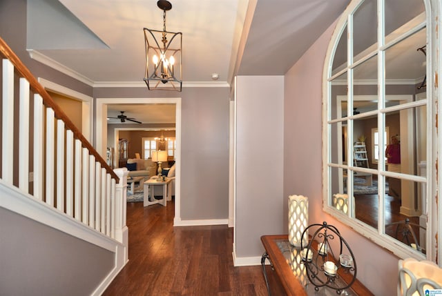 foyer entrance with ceiling fan with notable chandelier, ornamental molding, and hardwood / wood-style flooring