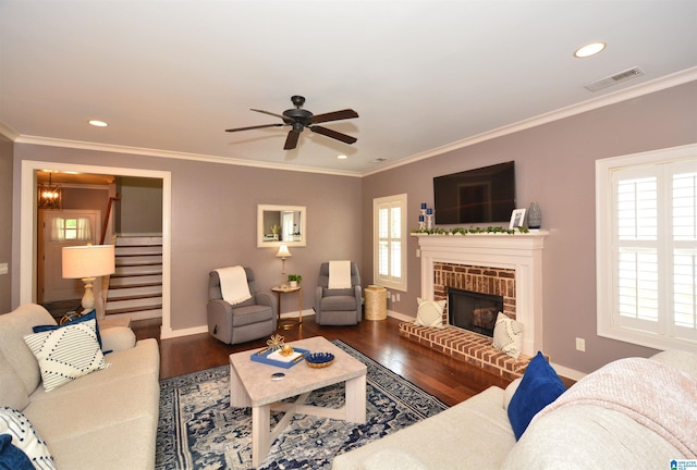 living room with hardwood / wood-style floors, ceiling fan, a wealth of natural light, and a brick fireplace