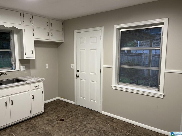 kitchen featuring white cabinets, tasteful backsplash, and sink