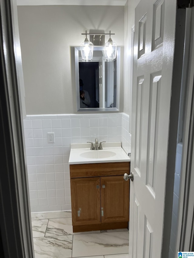 bathroom with vanity and tile walls