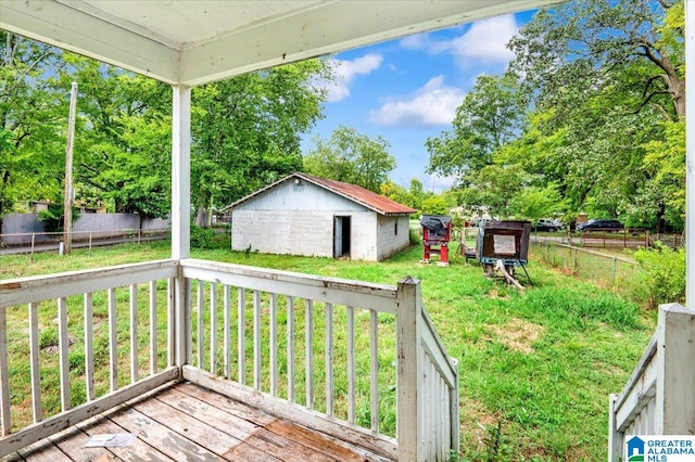 wooden deck with a lawn and a storage unit