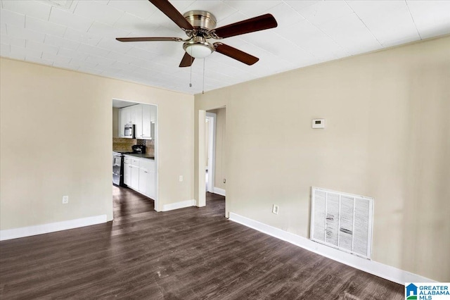 empty room featuring dark wood-type flooring and ceiling fan