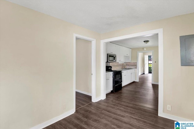 interior space featuring electric panel, a textured ceiling, dark hardwood / wood-style floors, and sink