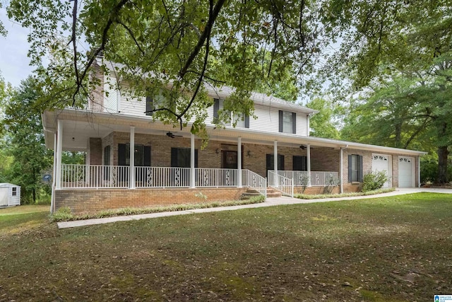 view of front of home featuring a garage, covered porch, and a front lawn