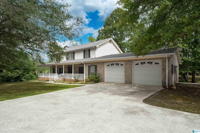 view of front facade with a front lawn, covered porch, and a garage