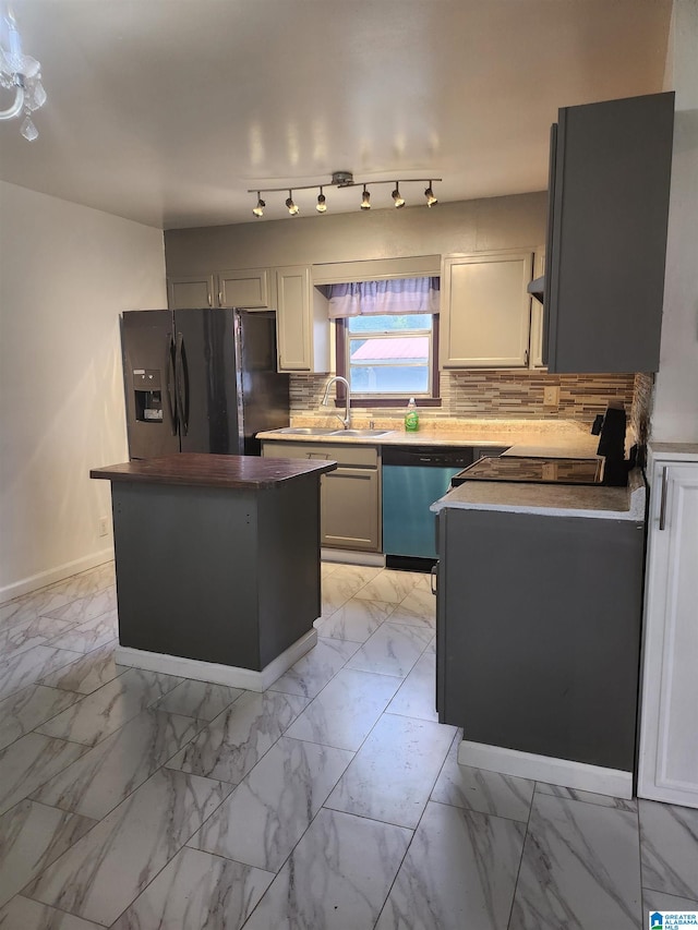 kitchen with gray cabinets, sink, decorative backsplash, stainless steel dishwasher, and black fridge