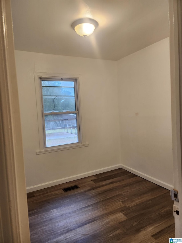 spare room with dark wood-type flooring