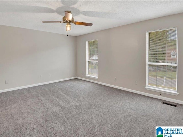 unfurnished room featuring a textured ceiling, ceiling fan, and carpet floors