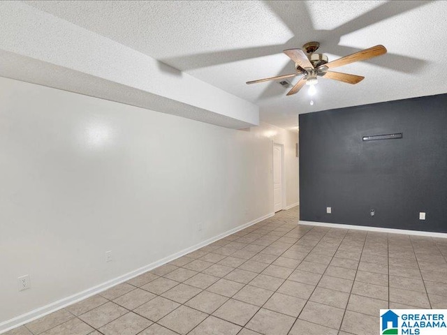 empty room with a textured ceiling, light tile patterned floors, and ceiling fan