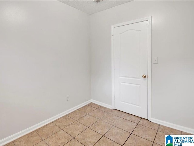 tiled spare room with a textured ceiling