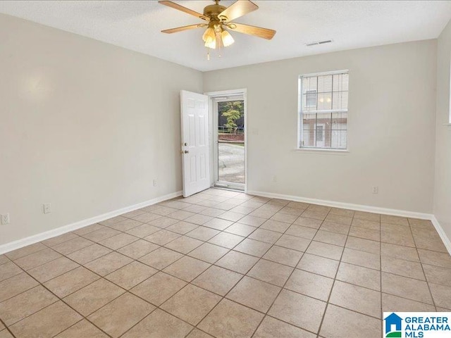 empty room with ceiling fan and light tile patterned floors