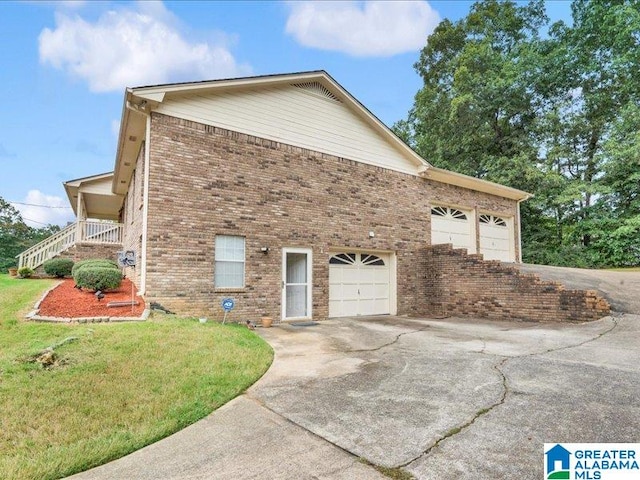 view of side of home featuring a garage and a lawn