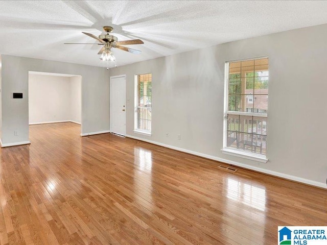 unfurnished room with a textured ceiling, ceiling fan, and light hardwood / wood-style floors