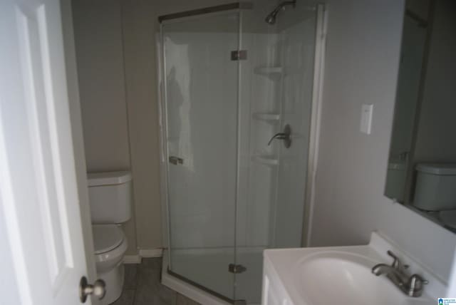 bathroom with an enclosed shower, tile patterned floors, toilet, and vanity