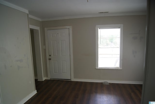 empty room featuring dark hardwood / wood-style flooring and ornamental molding