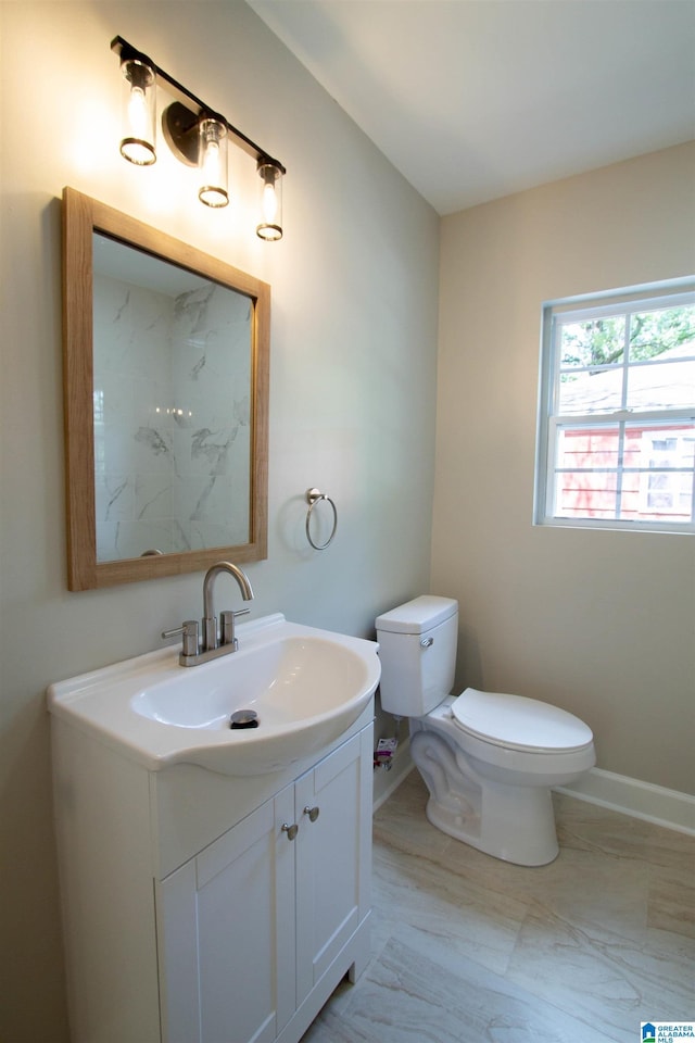 bathroom featuring vanity, toilet, baseboards, and marble finish floor