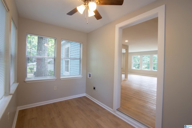 spare room with baseboards, wood finished floors, and a ceiling fan