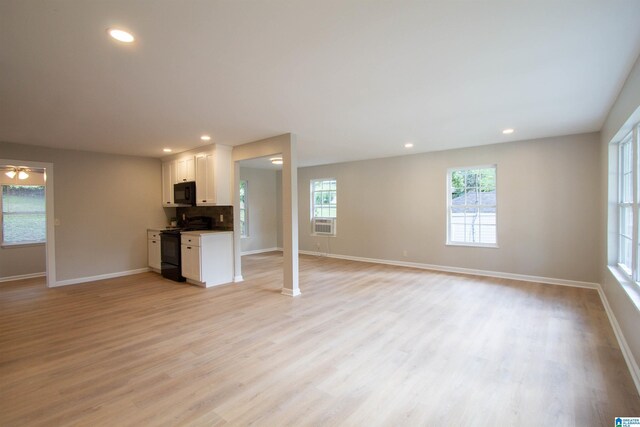 unfurnished living room with ceiling fan, cooling unit, decorative columns, and light hardwood / wood-style floors