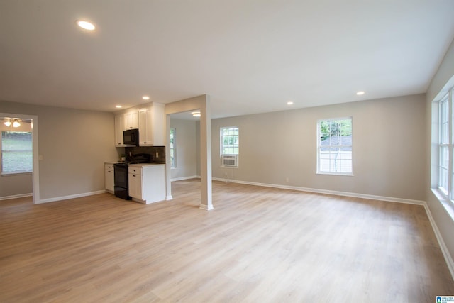 unfurnished living room featuring recessed lighting, baseboards, and light wood-style floors