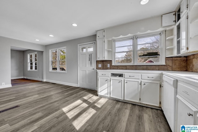 kitchen with dishwasher, light hardwood / wood-style floors, white cabinetry, and backsplash