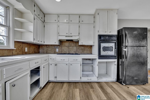 kitchen with decorative backsplash, light wood-type flooring, white cabinetry, and black appliances