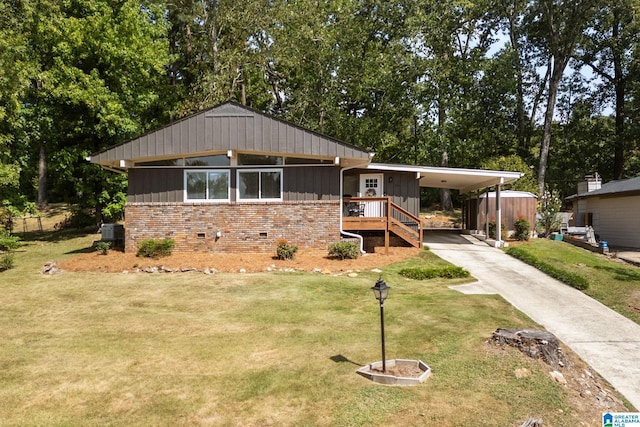 view of front facade featuring a front lawn, a carport, and central air condition unit