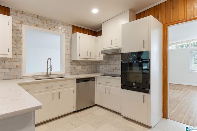 kitchen featuring white cabinetry, sink, backsplash, and black appliances