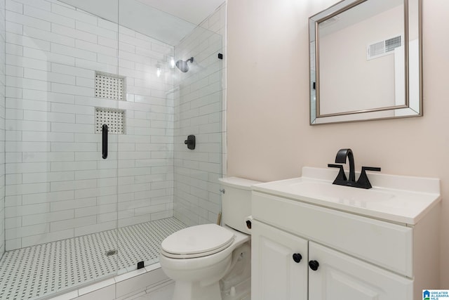 bathroom featuring vanity, a shower with door, and toilet