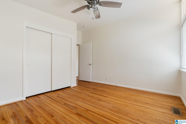 unfurnished bedroom with a closet, ceiling fan, and light wood-type flooring