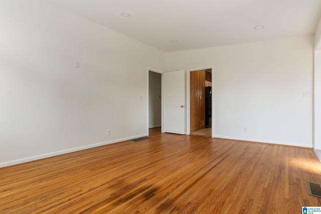 unfurnished room with vaulted ceiling and light hardwood / wood-style floors