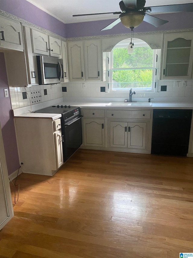 kitchen featuring dishwasher, light wood-type flooring, sink, ceiling fan, and stove