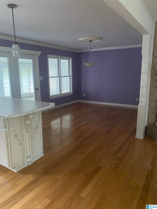 unfurnished dining area featuring light wood-type flooring and crown molding