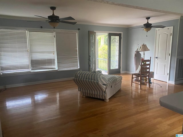 living room featuring crown molding, hardwood / wood-style flooring, and ceiling fan