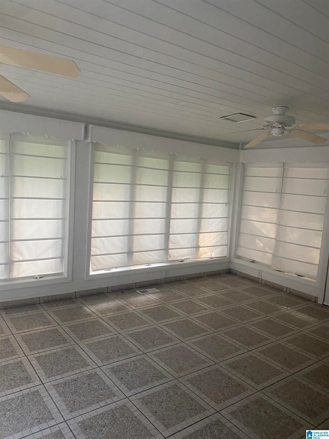 unfurnished sunroom with ceiling fan