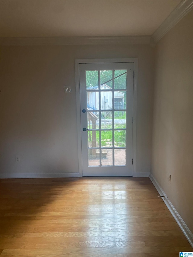 empty room with light wood-type flooring and ornamental molding