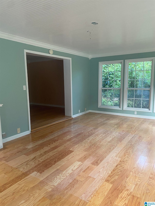 spare room with crown molding and light hardwood / wood-style floors