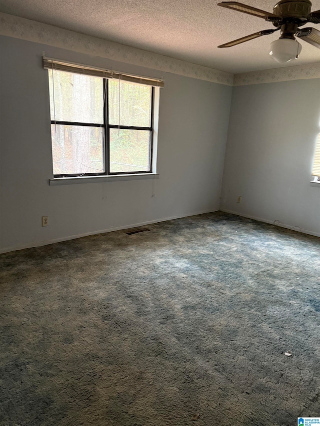 carpeted spare room with ceiling fan and a textured ceiling