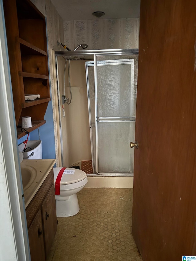 bathroom featuring vanity, toilet, and walk in shower