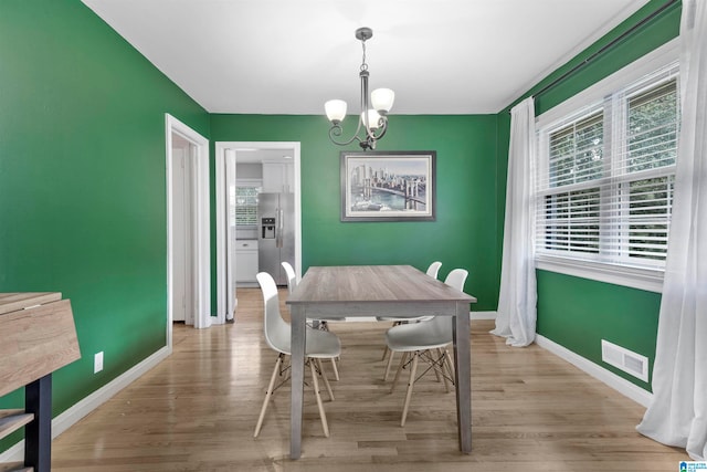 dining space featuring a chandelier and light hardwood / wood-style floors