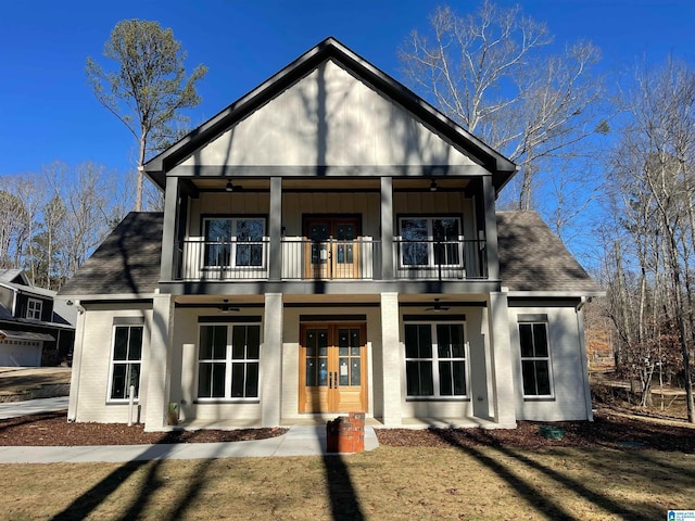 rear view of house with board and batten siding, french doors, a ceiling fan, and a balcony