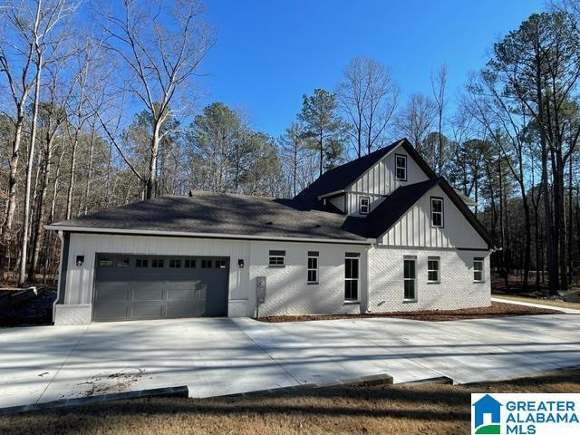 view of front of property featuring board and batten siding, a garage, and concrete driveway