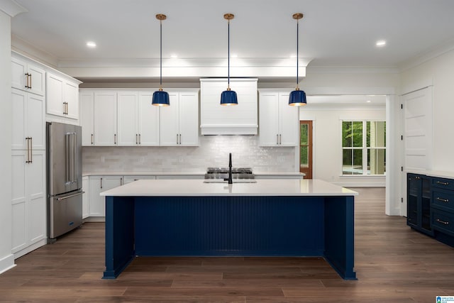 kitchen with ornamental molding, an island with sink, dark wood-style floors, light countertops, and high quality fridge