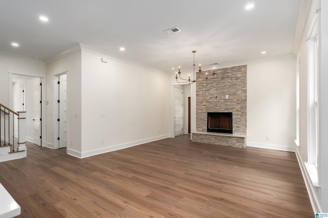 unfurnished living room featuring crown molding, visible vents, a notable chandelier, and stairs